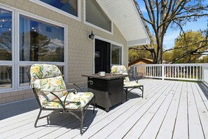 Una terraza techada al aire libre con muebles de mimbre y una mesa.