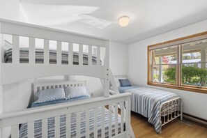 Una habitación con literas, una ventana con vistas y una lámpara en el techo.