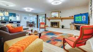Ein Wohnzimmer mit einer Couch, einem Hocker und einem Fernseher, der das Logo der FIFA Fussball-Weltmeisterschaft zeigt.