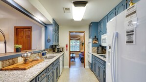 Eine Küche mit blauen Schränken, einem weißen Kühlschrank und einer Holz Arbeitsplatte.