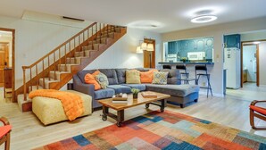 Ein Wohnzimmer mit Sofa, Couchtisch und einer Treppe.