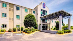 A hotel with a covered entrance, multiple windows, and a prominent '6' sign. - 2 Queen Beds|Non-Smoking (El Reno)