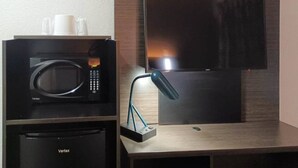 A kitchenette with a microwave, a coffee maker, and a flat-screen TV mounted on the wall. - 2 Full Beds | Micfridge, Smoking (Fresno CA)