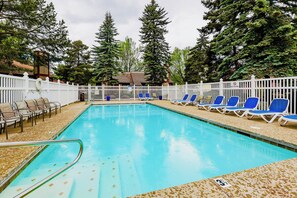A swimming pool with lounge chairs and a white fence. - Hot Tub/Pool/Near Lake/Whitefish Resort/Dining (Whitefish)
