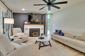 A living room with a fireplace, sofa, armchair, and a ceiling fan. - < 1 Mi to Bull Shoals Lake! Family-Friendly Escape (Lakeview)