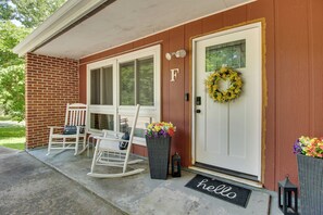 A house with a brick exterior, a white front door with a wreath, two rocking chairs, and a 'hello' mat. - < 1 Mi to Bull Shoals Lake! Family-Friendly Escape (Lakeview)