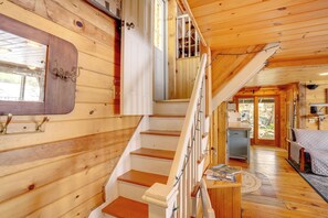 Un interior de madera con una escalera, un comedor y una cocina.