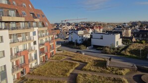 Ein Wohngebiet mit modernen Wohngebäuden, einer Straße und einer entfernten Baustelle.