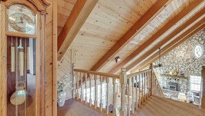 A wooden interior with a large clock, wooden beams, a stone wall, and a staircase. - 25-Acre Hideaway in Oakhurst: Pet Friendly! (Oakhurst)