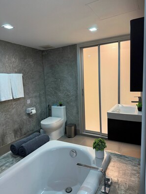 Une salle de bain moderne avec une baignoire, des toilettes et un lavabo.