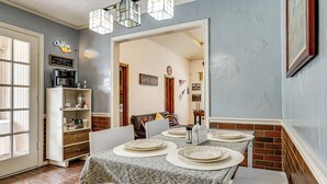 Zona pranzo con tavolo apparecchiato per quattro, angolo caffè e cartello per la sala giochi.