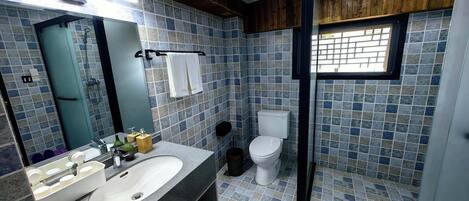A bathroom with a tiled floor, a sink, a toilet, and a shower area.