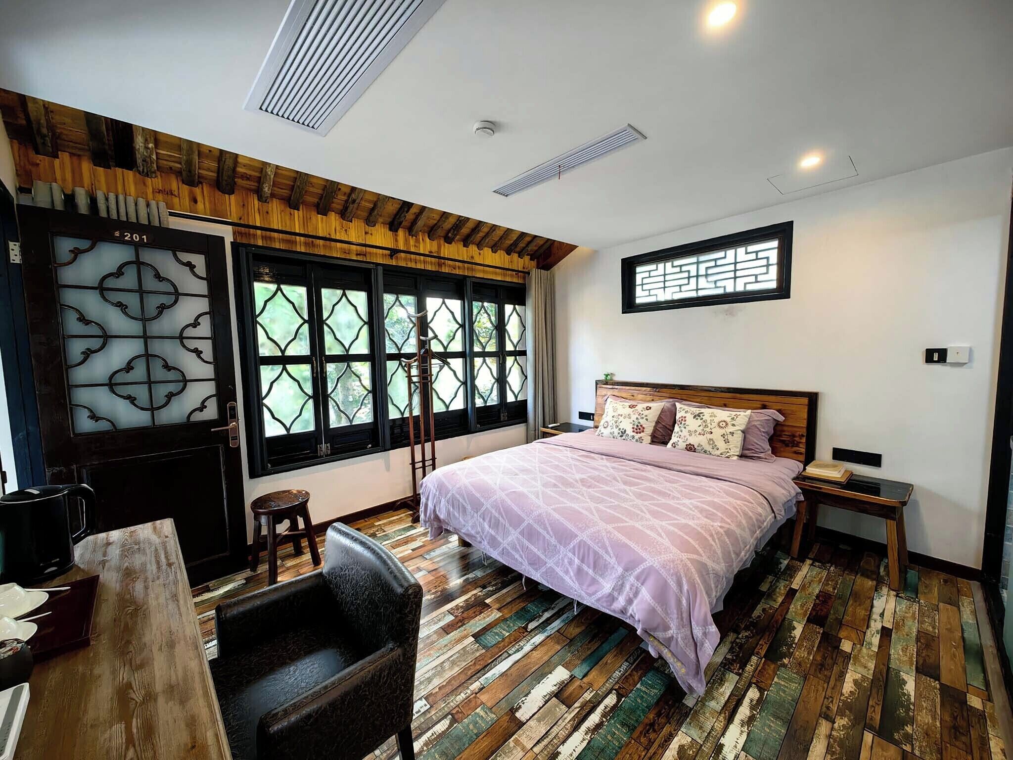 Um quarto com uma cama, uma escrivaninha e uma cadeira.