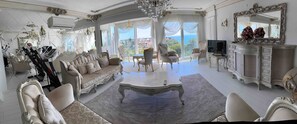 A luxurious living room with a sofa, chairs, a coffee table, a TV, and a large mirror. - King's apartment 10 min to Konyaalti beach (Muratpaşa)
