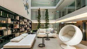 Ein modernes Interieur mit einer Couch, einem runden Sessel und einem Bücherregal.