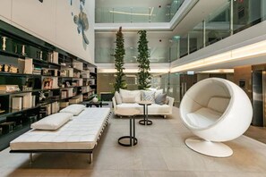 Ein modernes Interieur mit einer Couch, einem runden Sessel und einem Bücherregal.