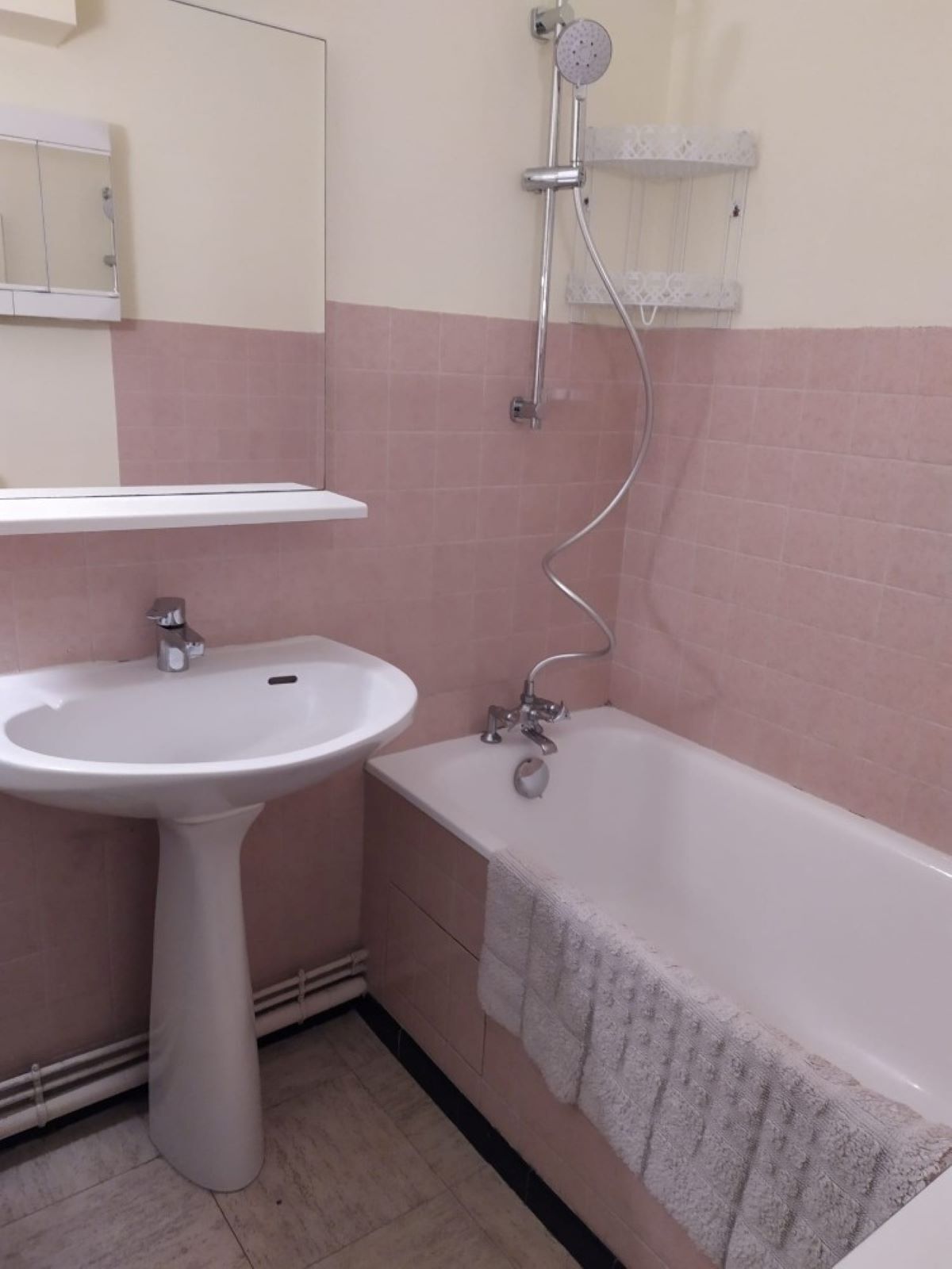 A bathroom with a pedestal sink, a bathtub, and a shower.
