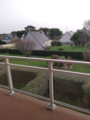 Varanda com vista para uma área residencial, incluindo casas e um viveiro.