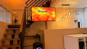 Een trap met een flatscreen-televisie waarop staat: 'Aladdin, ik laat u de wereld zien', en een draadloze speaker op de vloer.