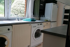 A laundry area with a washing machine, a sink, and a window. - Les Rainettes – Quiet family home with garden and terrace in the Ardennes (Grand-Halleux)