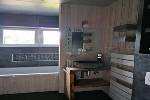 A modern bathroom with a wooden vanity, a large mirror, and a built-in sink. - Les Rainettes – Quiet family home with garden and terrace in the Ardennes (Grand-Halleux)