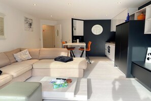 Eine moderne Wohnung mit Wohnzimmer, Essbereich und Küche.
