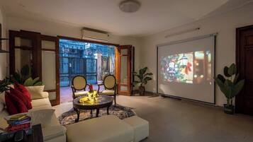 Un salon avec un canapé, une table basse et un écran de projection diffusant une scène de Noël.