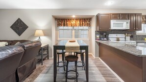 A compact kitchen with a dining table, bar stools, a microwave, and a stove. - View of Table Rock Lake - Minutes from SDC - PERFECT! (Branson)