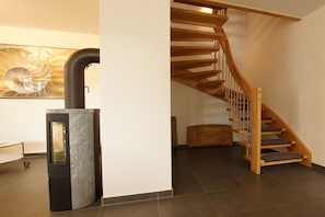 Un intérieur moderne avec un escalier à volutes, une cheminée et une œuvre d’art accrochée au mur.