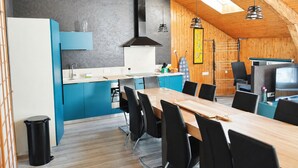Una cocina moderna con comedor, techo de madera y televisor.