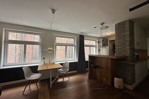 A modern kitchen with a wooden countertop, a built-in stove, and a brick accent wall. - Holiday apartment with 0 bedrooms (Lübeck)