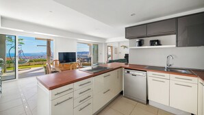 Une cuisine moderne avec des armoires blanches, un plan de travail en bois et un lave-vaisselle.