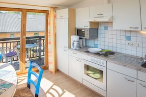 Una cocina equipada con microondas, cafetera y horno.