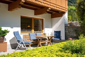 Ein Gebäude mit Balkon, Holzmöbeln und einem Fenster.
