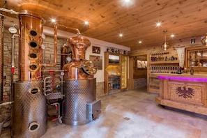 A distillery interior with copper stills, a bar area, and wooden walls. - Spitaler holiday apartment (Hippach)