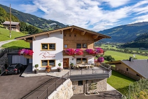 A two-story building with a balcony, a sign reading 'Spitaler,' and a view of a valley. - Spitaler holiday apartment (Hippach)