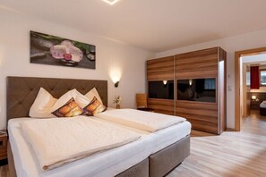 Ein Schlafzimmer mit einem großen Bett, einem Holzschrank und einem Gemälde an der Wand.
