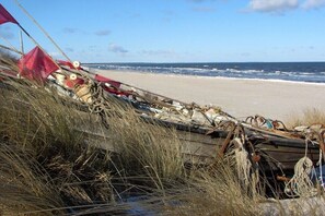 Ein Strand mit einem Boot und etwas Treibgut.
