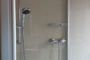 Ducha con cabezal de ducha de mano y grifo empotrado.