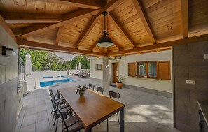 A covered patio with a pool, a dining table with chairs, and a view of the outdoors. - Amazing home in Sapjane (Sapjane)