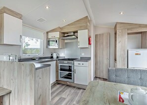 Eine kleine Küche mit Mikrowelle, Herd, Backofen und Spüle.