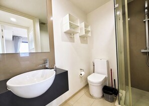 A modern bathroom with a large white sink, a toilet, and a glass shower enclosure. - 1 BR Sea View Condo Near Walking Street (ตำบล หนองปรือ)