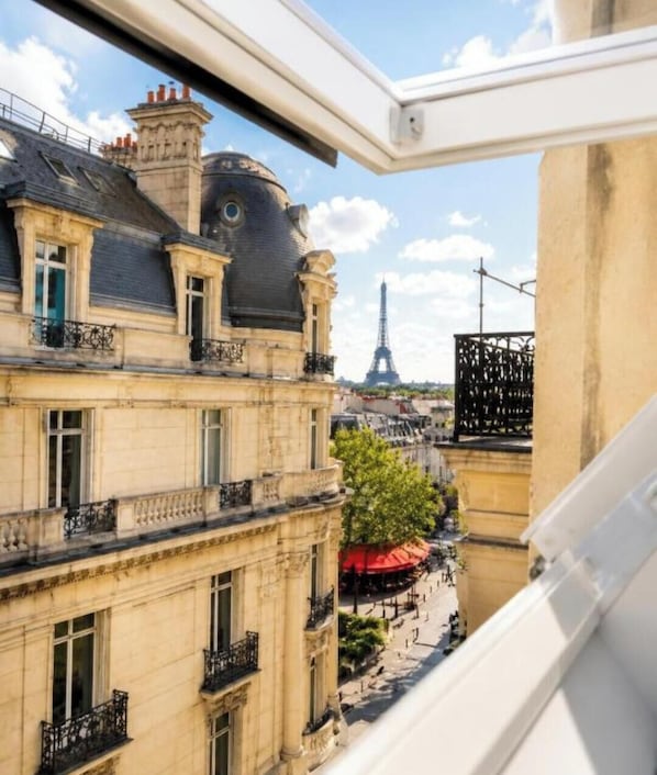 Une vue sur les bĂątiments parisiens, avec la Tour Eiffel en arriĂšre-plan.