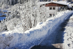 A snow-covered road with a building in the background. - Holiday home with 1 bedroom (Fieberbrunn)