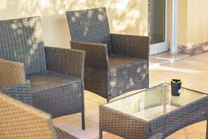 Wicker furniture with a glass table, a door, and tiled flooring. - BorgoNaro, an authentic oasis of peace located in the charming village of Dattilo. (Dattilo)