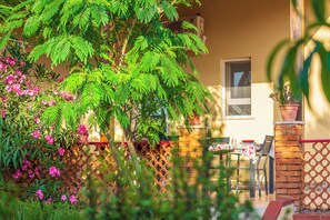 A patio with a table and chairs, a potted plant, and a fence. - BorgoNaro, an authentic oasis of peace located in the charming village of Dattilo. (Dattilo)