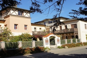 A multi-story building with balconies, a gated entrance, and a clear sky. - 22, Residenz Seestern (Kühlungsborn-West)