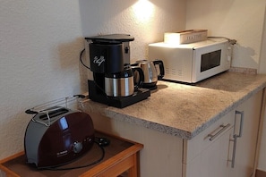 A kitchenette with a coffee maker, toaster, microwave, and a tea box. - Holiday apartment with 1 bedroom (Amelinghausen)