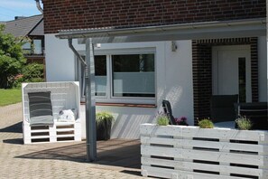 Ein Wohngebäude mit überdachter Veranda, einem Fenster und einer Tür.