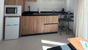 A modern kitchen with a microwave, stove, and wooden cabinets.